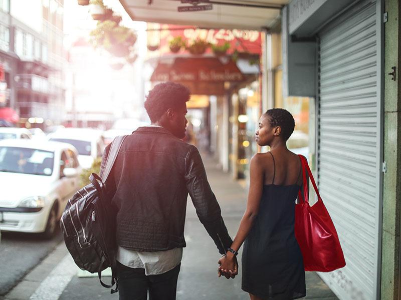 couple walking down street in city area